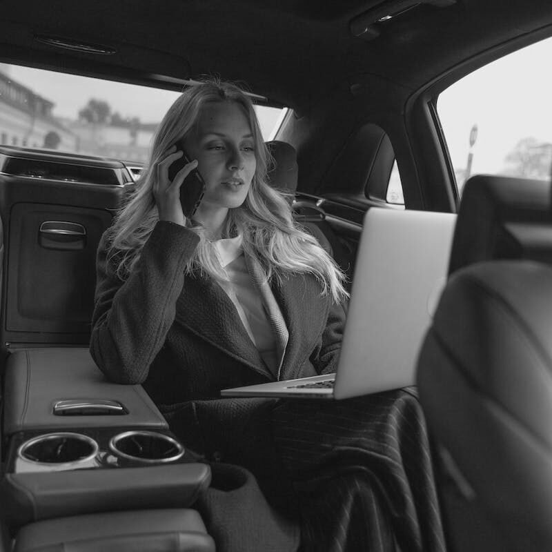 Woman in Gray Business Suit Sitting In A Luxurious Car